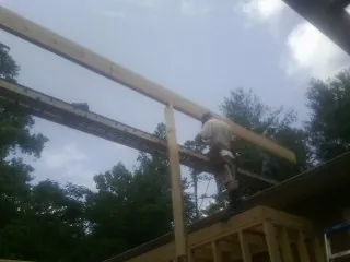 Carpenter setting a ridge beam over a new addition frame — Ice Dam Removal by Roofing Brothers in Scotia