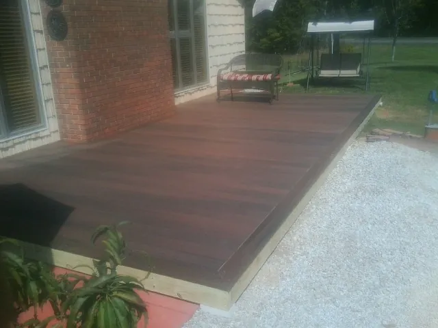 Freshly stained wood deck built against a brick home in Scotia