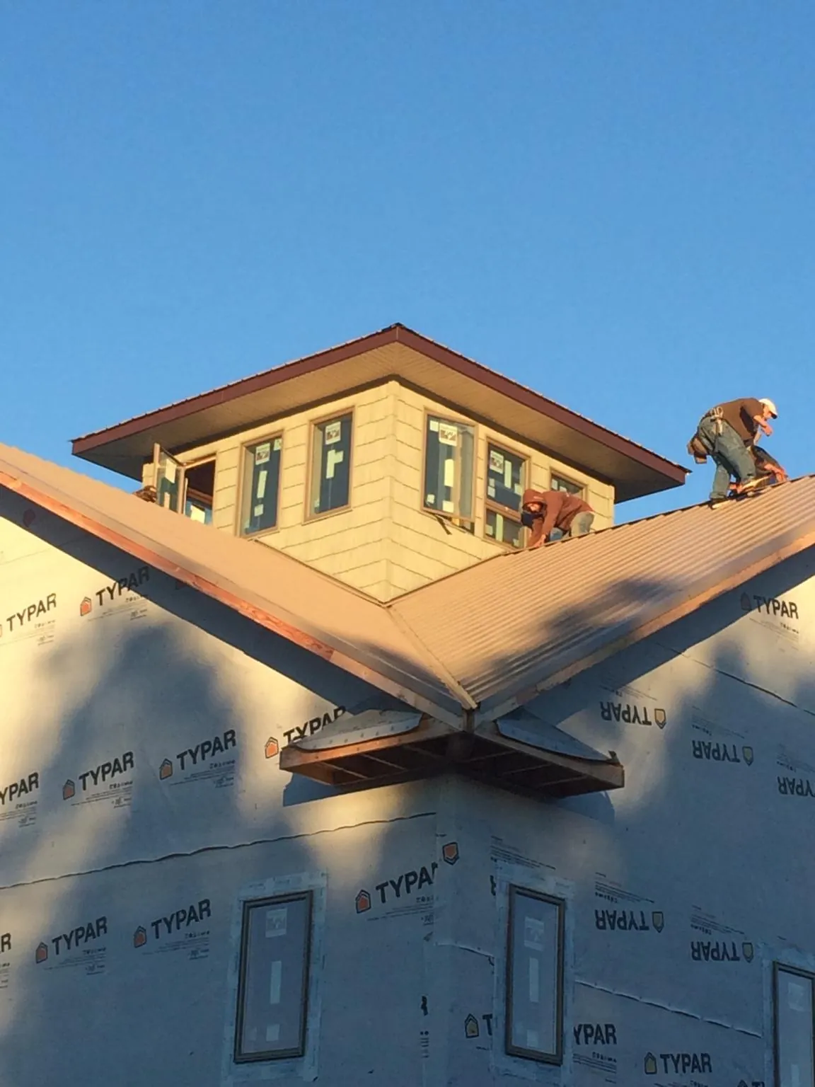Roofers working around a rooftop cupola on a new metal roof at sunset — Roof Waterproofing in Scotia by Roofing Brothers